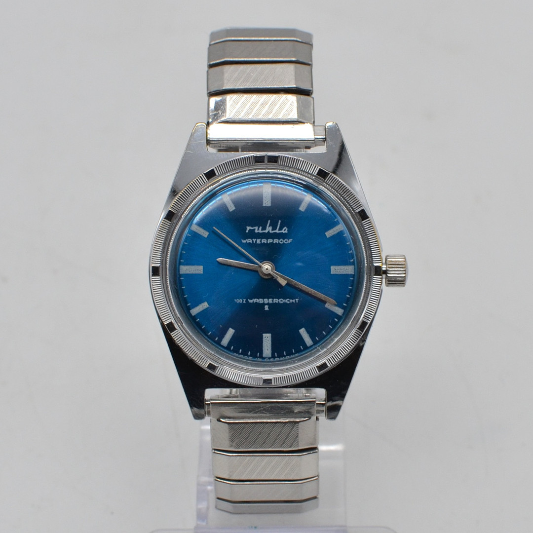 RUHLA, ARMBANDUHR, WATERPROOF, BLAUES ZIFFERBLATT, GEHÄUSE UND FLEXARMBAND AUS EDELSTAHL, MIT HANDAUFZUG, DEUTSCHLAND, UM 1969.