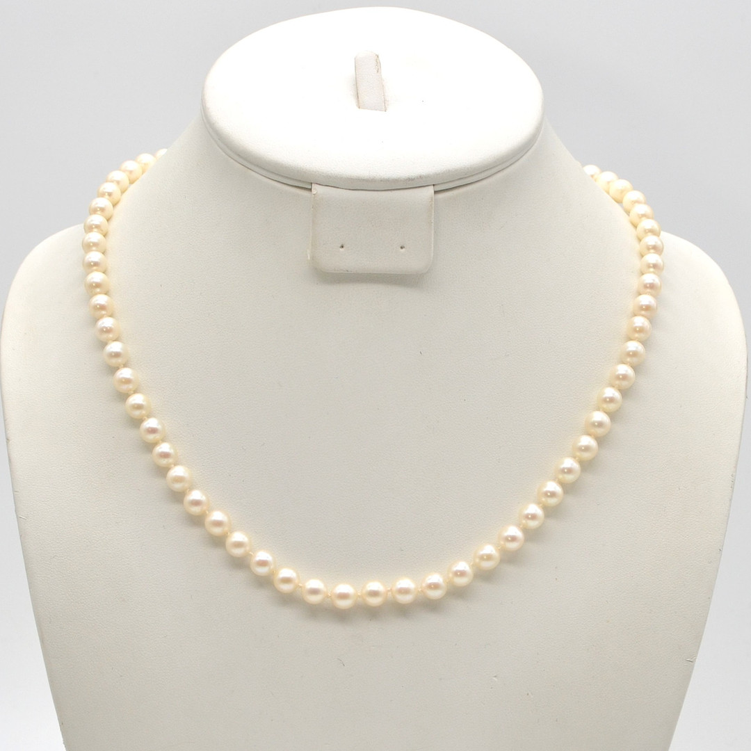 AKOYA PERLENCOLLIER, RUNDE PERLEN, CREMEFARBENER LÜSTER, EINZELN GEKNÜPFT, STERLINGSILBERVERSCHLUSS, 20. JAHRHUNDERT.