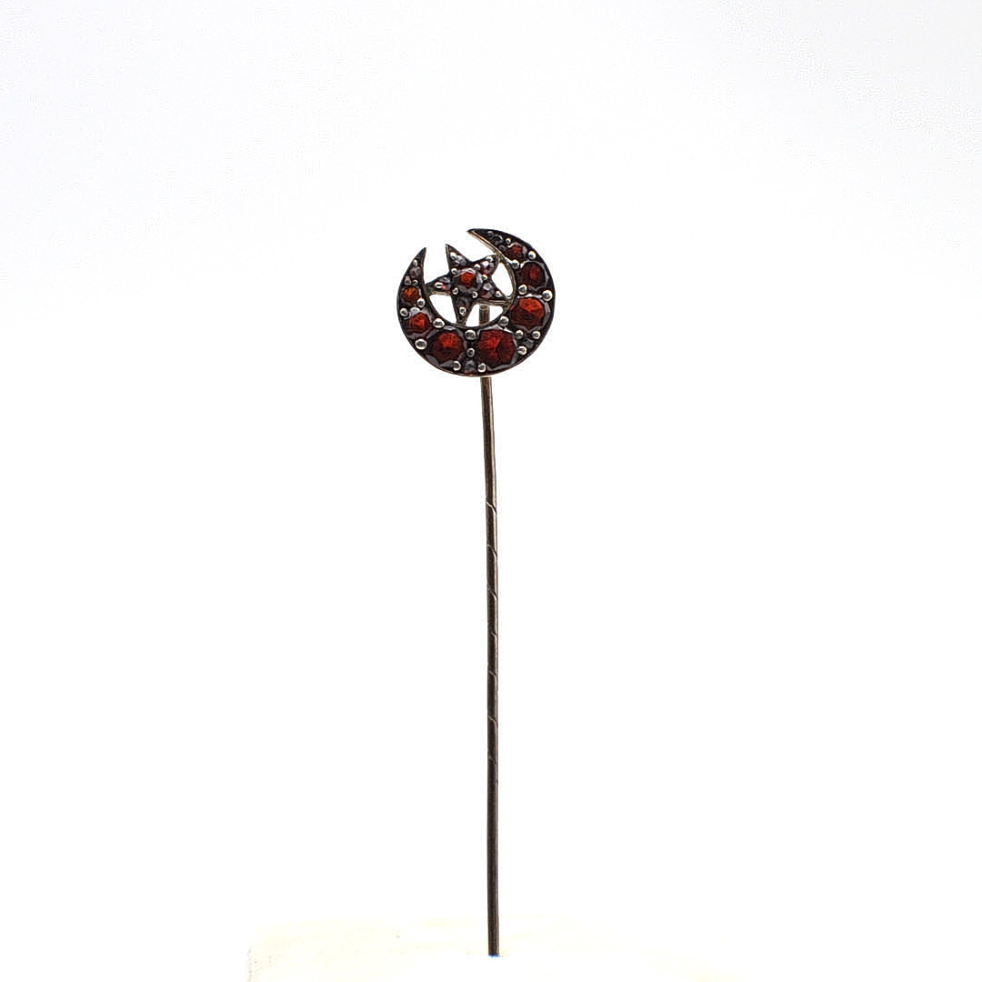 JUGENDSTIL KRAWATTENNADEL MIT GRANATEN, MOND UND STERN, UM 1900.