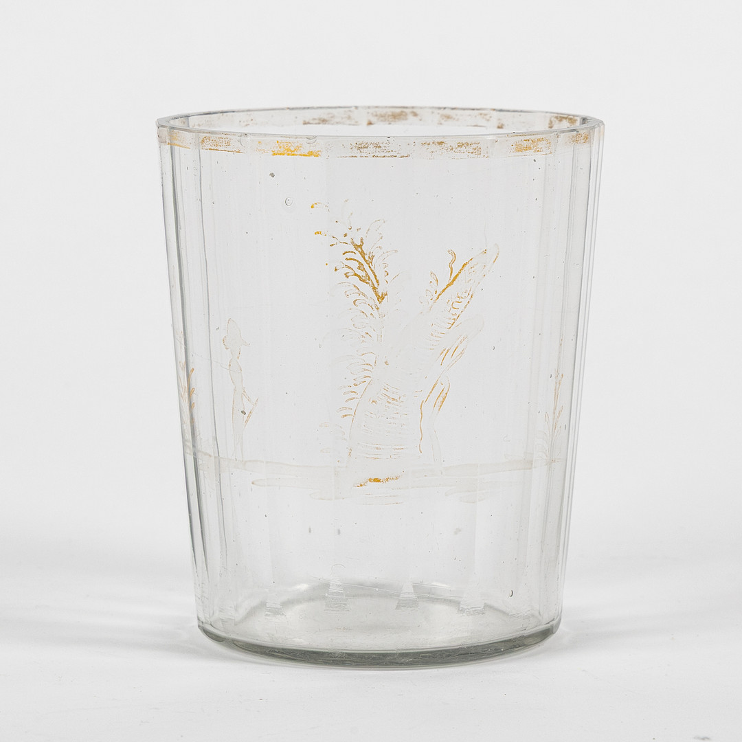 GLAS, sannolikt 1700-tal, fasettslipat med förgylld kant samt dekor av person i trädgårdslandskap.