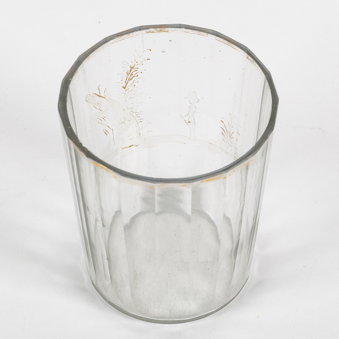 GLAS, sannolikt 1700-tal, fasettslipat med förgylld kant samt dekor av person i trädgårdslandskap.