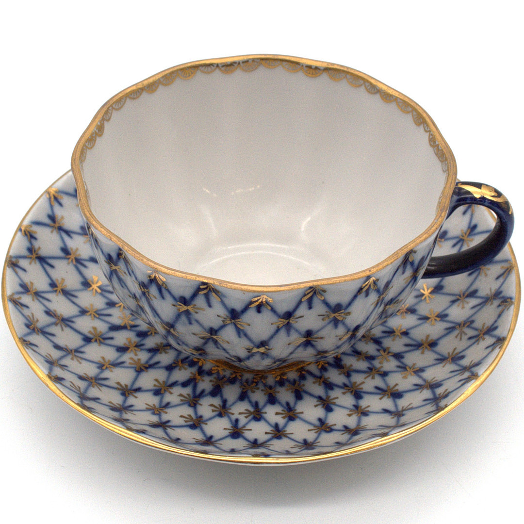 KAISERLICHE PORZELLANMANUFAKTUR LOMONOSSOW. „KOBALTNETZ“ TASSE SOWIE UNTERTASSE, HANDBEMALT KOBALTBLAU MIT GOLDENEN AKZENTEN. RUSSLAND 20. JAHRHUNDERT.