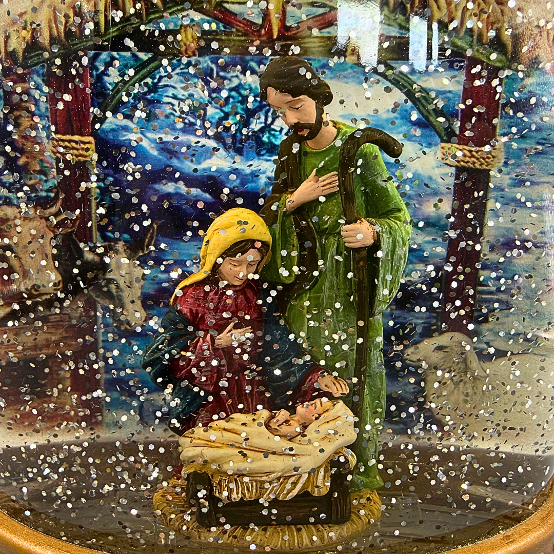 BELEUCHTETE SCHNEEKUGEL AUS GLAS MIT DER KRIPPENSZENE.