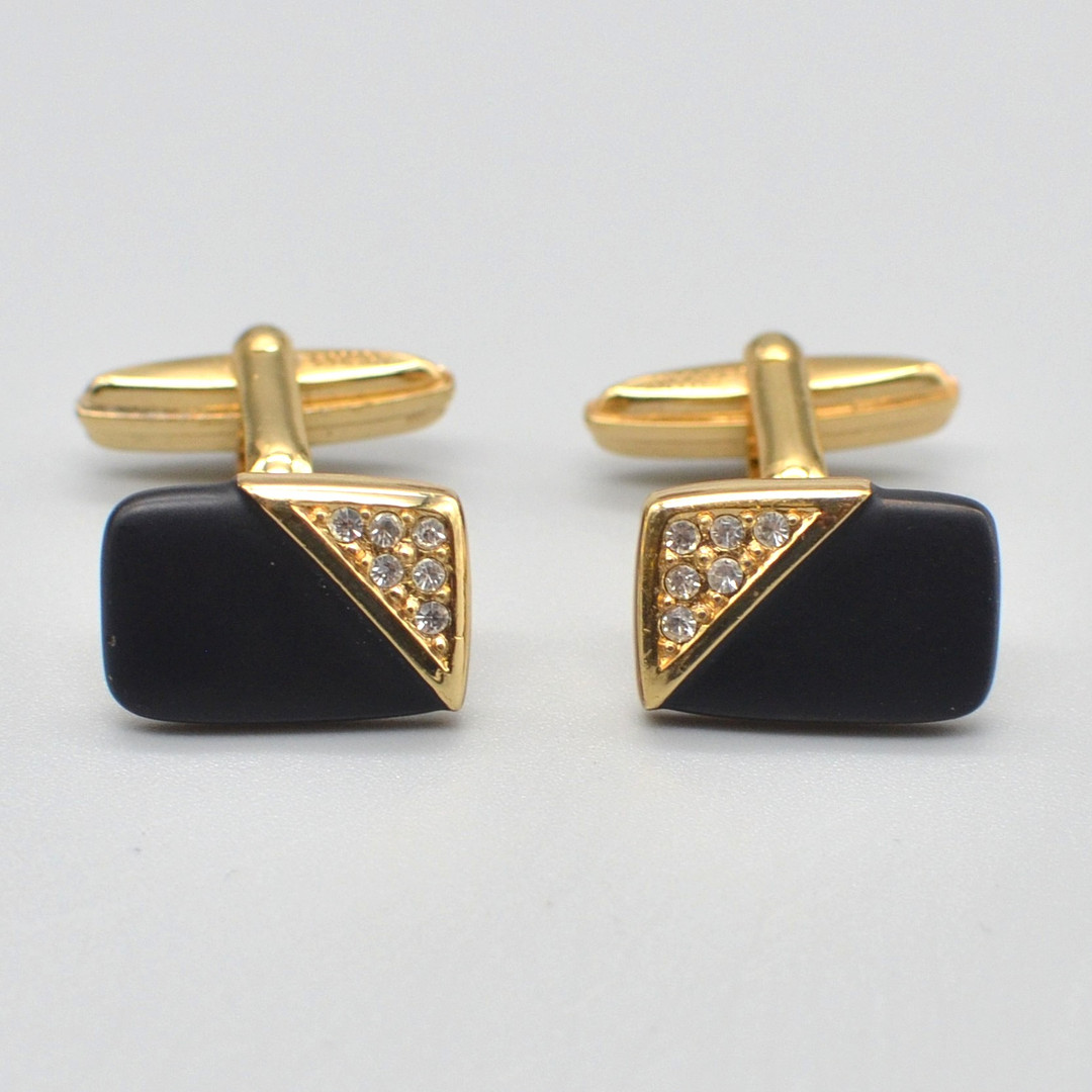 CHRISTIAN DIOR. DESIGNER-MANSCHETTENKNÖPFE, ONYX, STRASSSTEINE, VERGOLDETE FASSUNG, UM 1950, MIT ORIGINALVERPACKUNG.