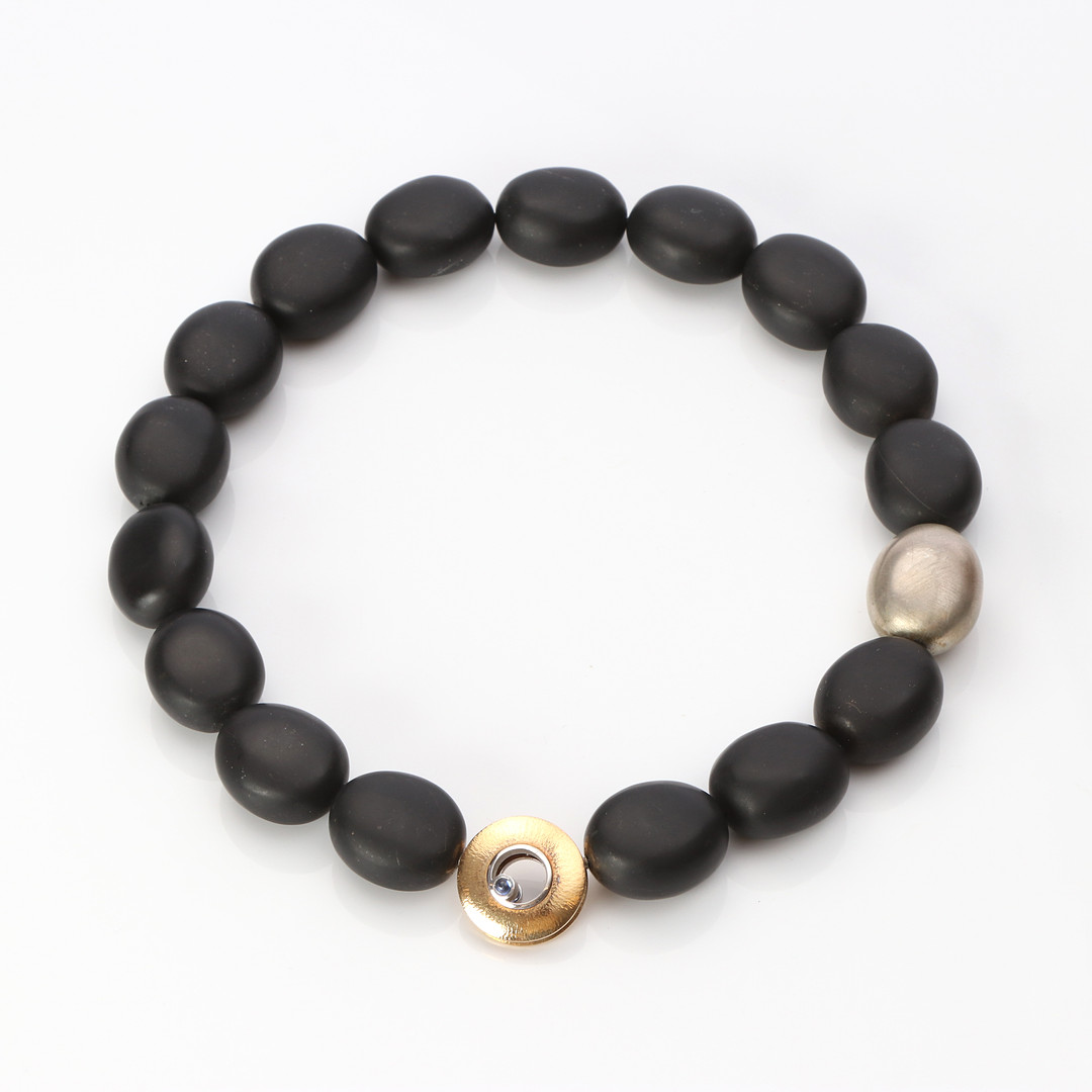 OLE LYNGGAARD, COLLIER MED LÅS. Lås "Luna" i 18k röd- och vitguld med en briljantslipad diamant och en safir, collier med polerad svart sten och silver.