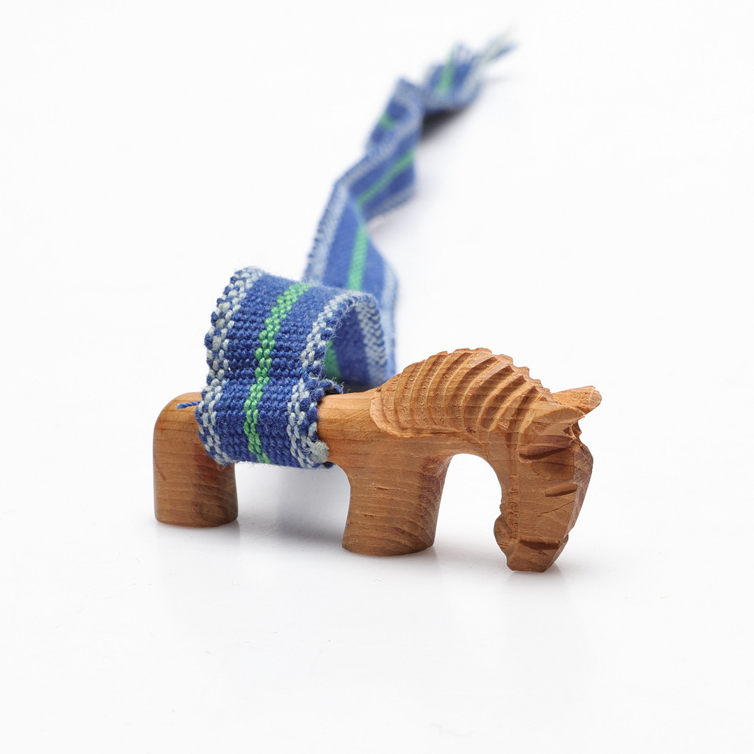 SKULPTUR/BOKMÄRKE, snidat trä samt vävd textil. Signerad.