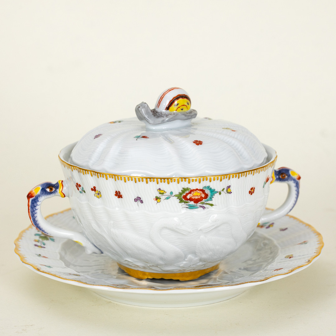 JOHANN JOACHIM KAENDLER (FISCHBACH/SACHSEN 1706 - MEISSEN 1775). Suppentasse und Teller aus dem Schwanenservice mit poychromer Bemalung.