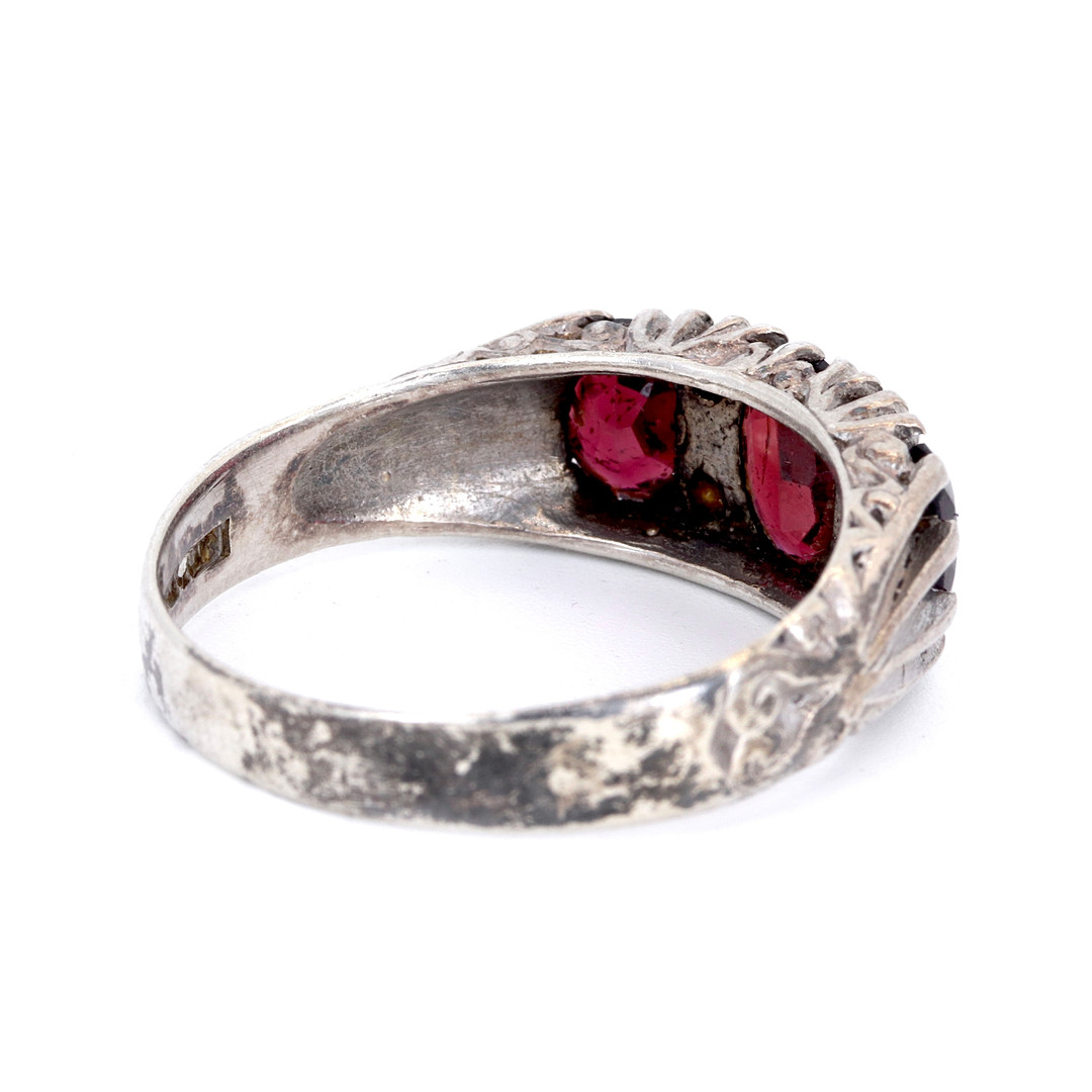 SILVER GARNET SET THREE STONE RING.