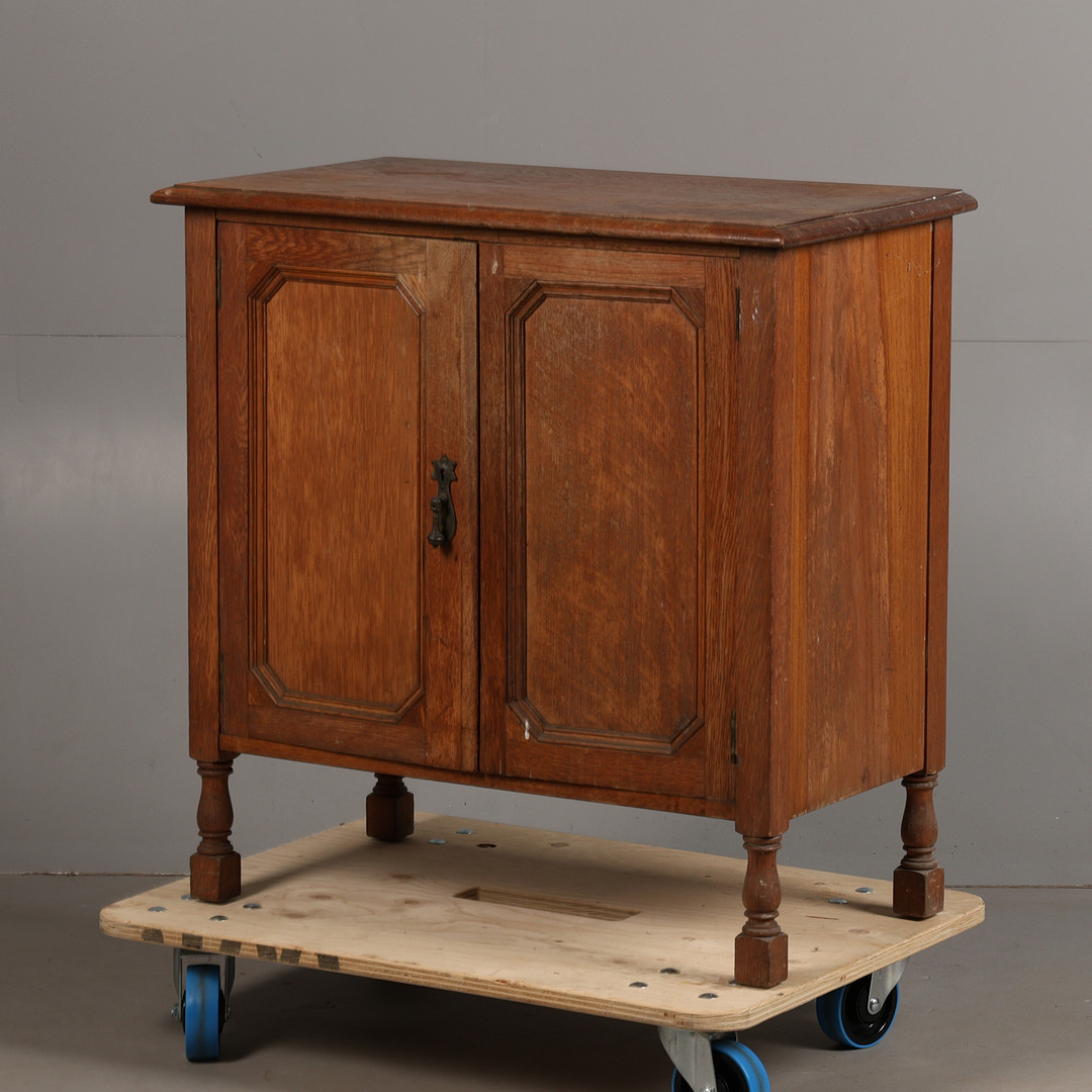 A SMALL EARLY 20TH CENTURY OAK CUPBOARD BY WARING & GILLOW.