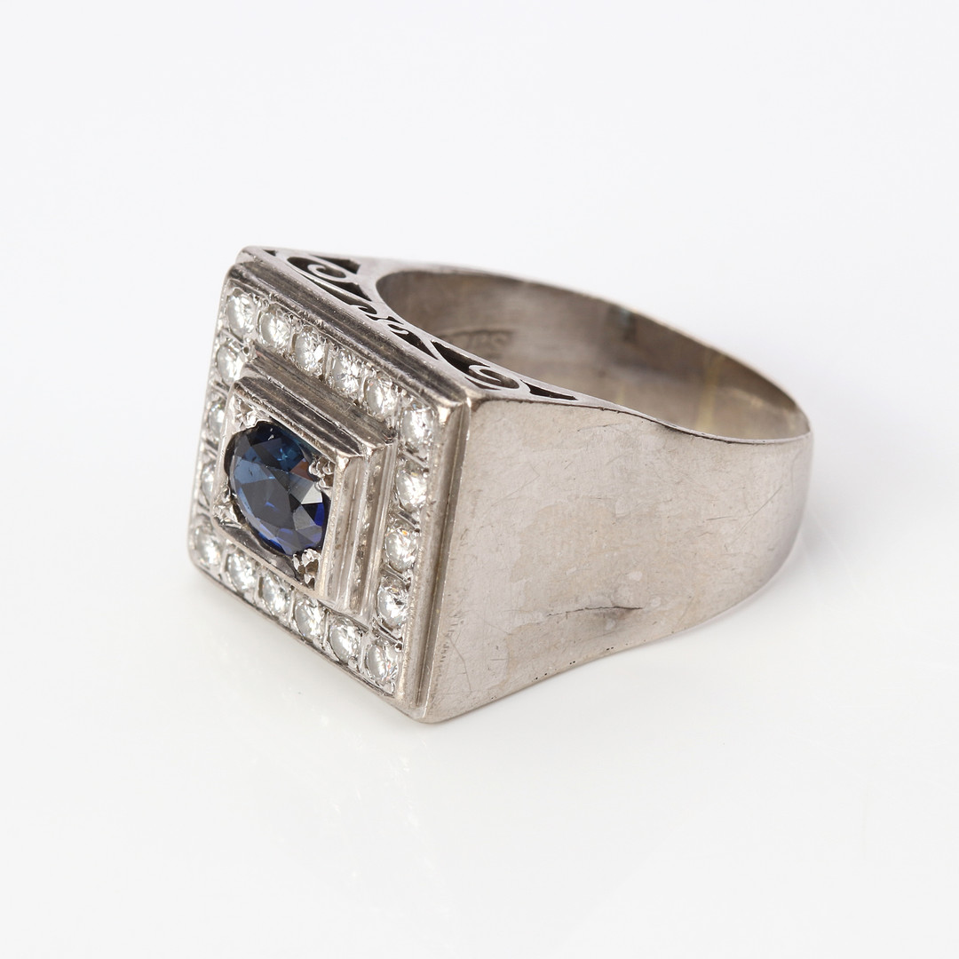 SAFIRRING. 18k vitguld med en oval fasetterad safir och briljantslipade diamanter, totalvikt ca 12,2 gram.