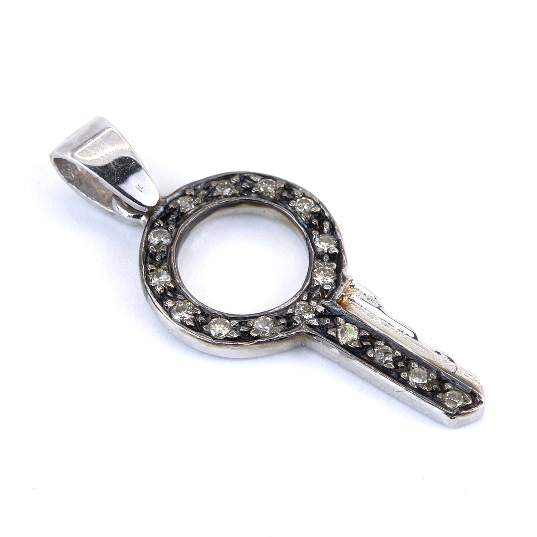 18CT WHITE GOLD DIAMOND SET KEY SHAPED PENDANT.