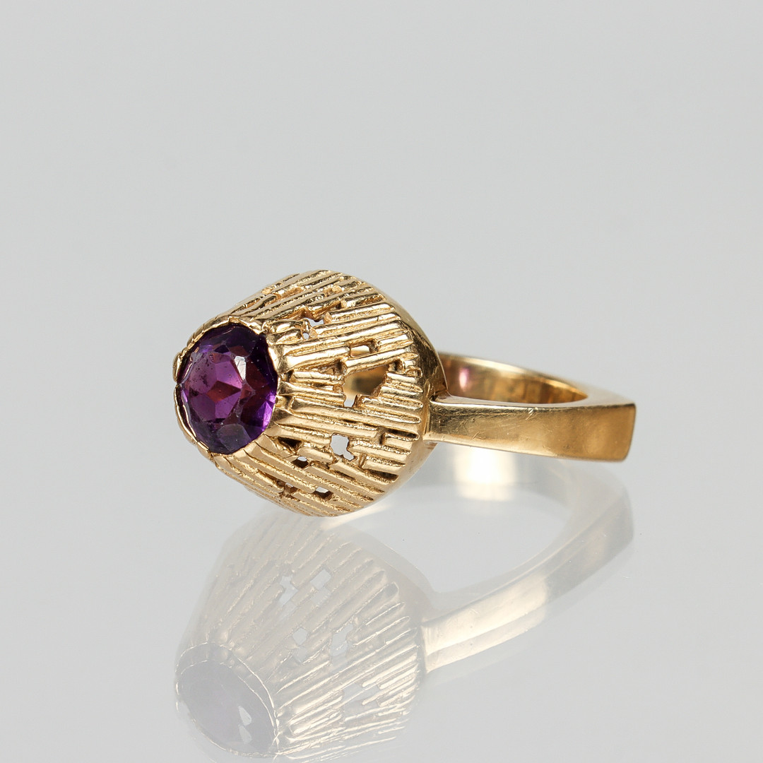 RING, 18k guld med facettslipad lila sten, BJK, Stockholm 1969.