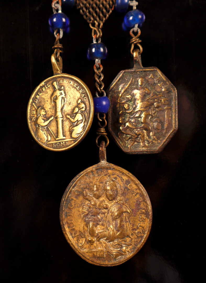 Placa de cofradía española en acero, con la representación de Santiago en la batalla de Clavijo, y rosario con tres medallas votivas italianas en bronce, de los siglos XVIII y XIX.