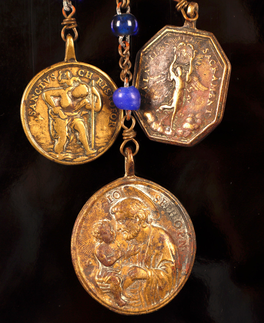 Placa de cofradía española en acero, con la representación de Santiago en la batalla de Clavijo, y rosario con tres medallas votivas italianas en bronce, de los siglos XVIII y XIX.