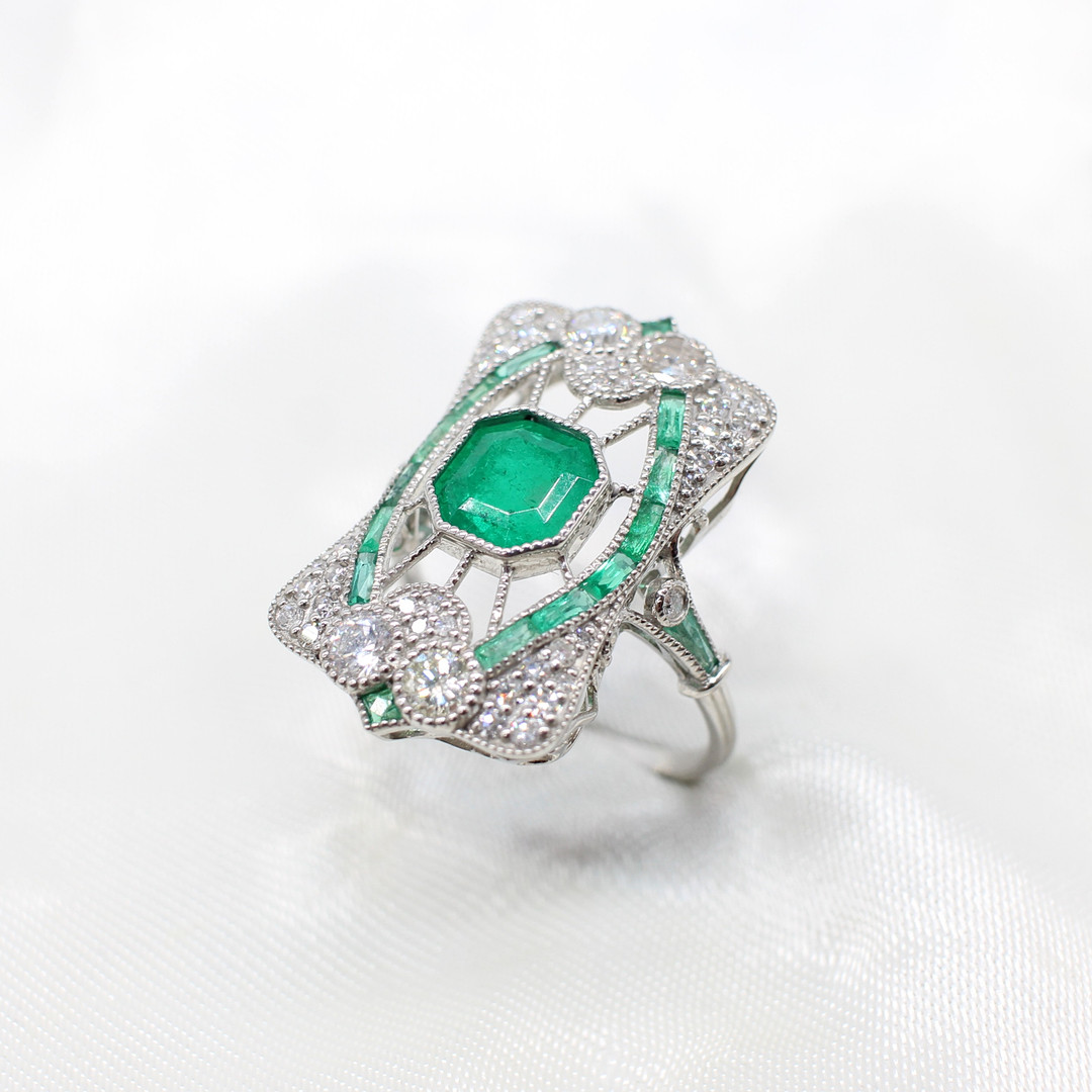 PLATINUM & EMERALD PANEL RING.