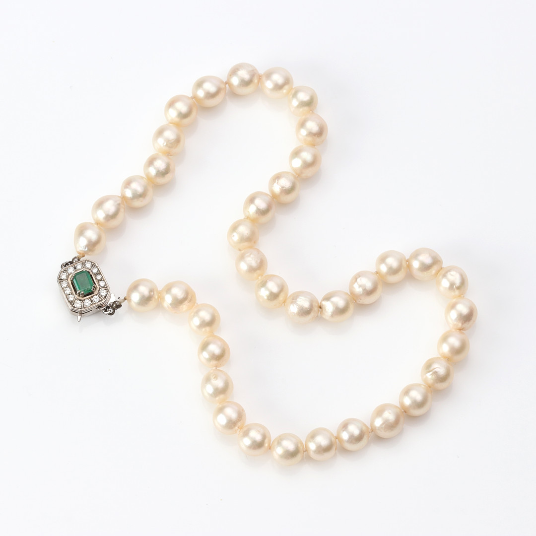 PÄRLCOLLIER. Odlade pärlor, lås i 18k vitguld med en fasetterad smaragd och briljantslipade diamanter.