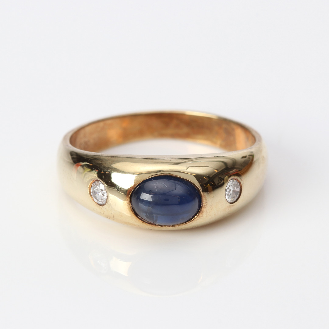 SAFIRRING. 14k guld med en cabochonslipad safir och två briljantslipade diamanter, totalvikt ca 5,1 gram.