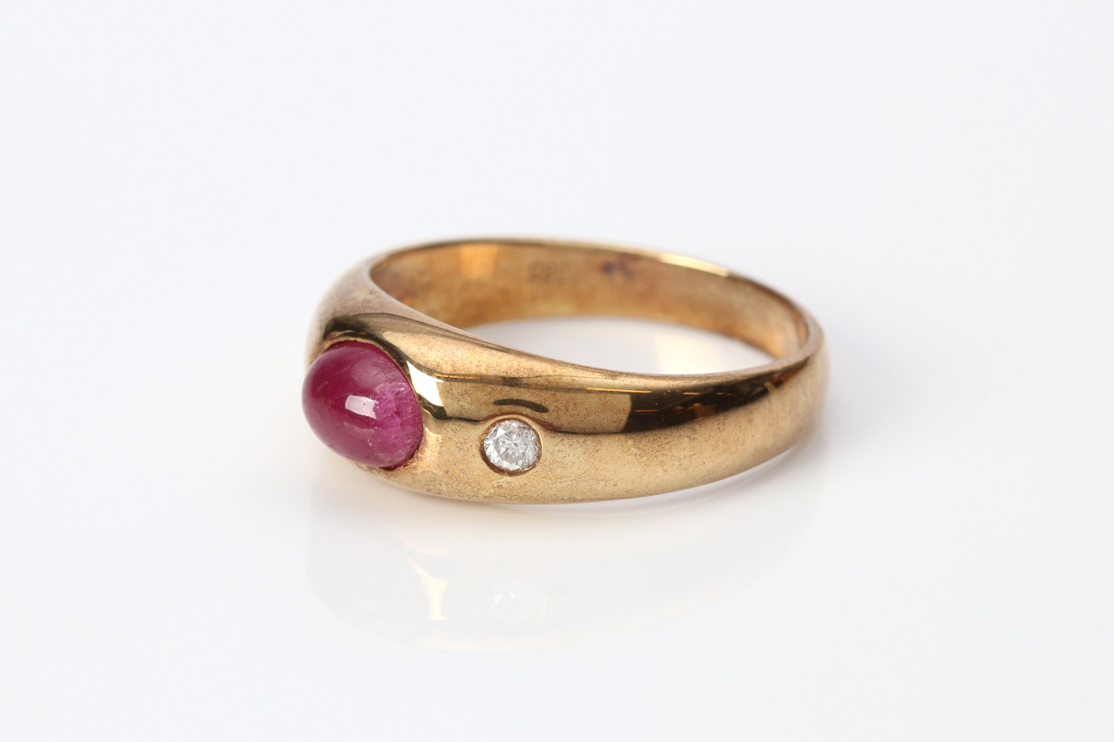 RUBINRING. 14k guld med en cabochonslipad rubin och två briljantslipade diamanter, totalvikt ca 4,8 gram.