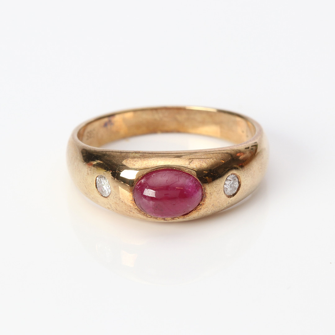 RUBINRING. 14k guld med en cabochonslipad rubin och två briljantslipade diamanter, totalvikt ca 4,8 gram.