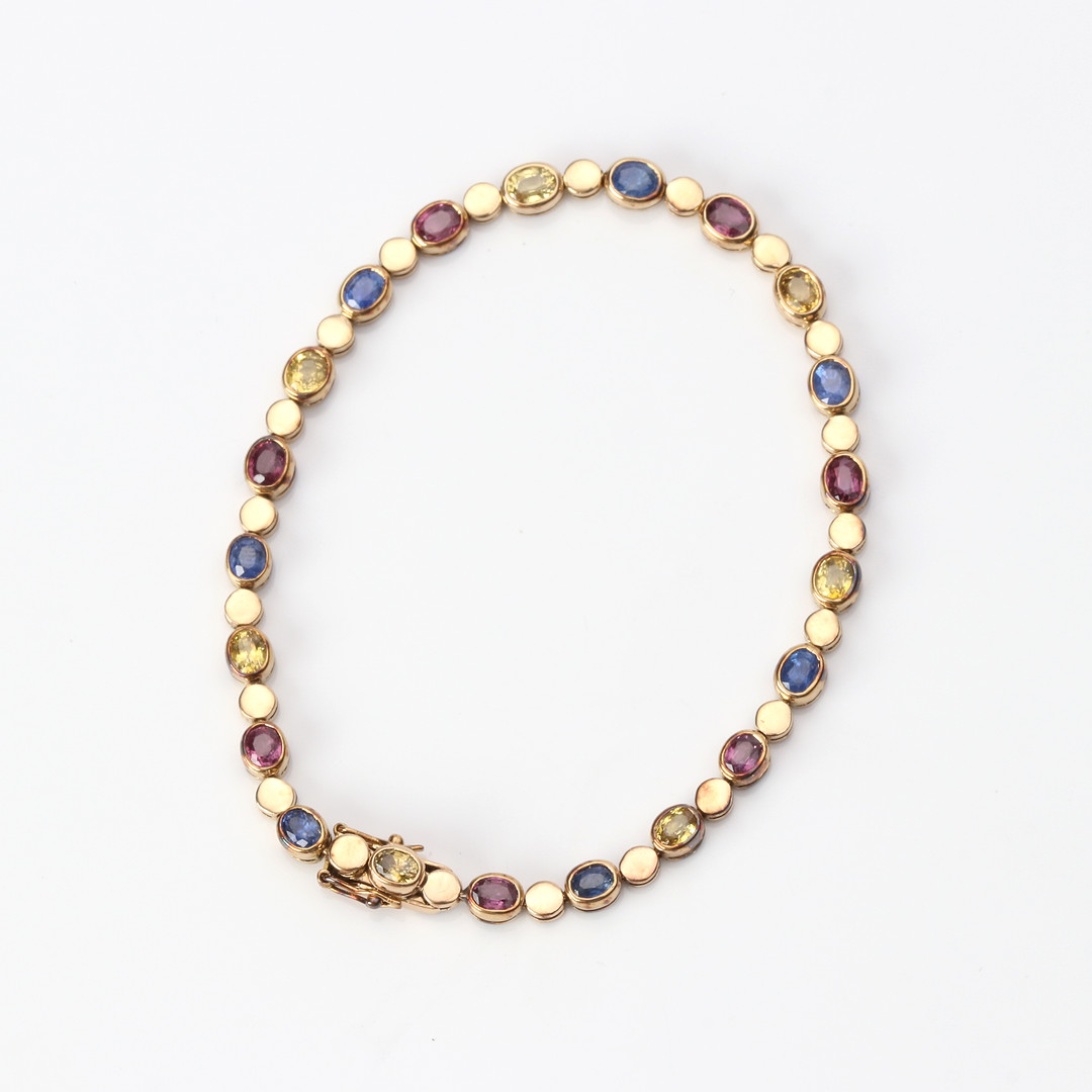 ARMBAND. 14k guld med rödrosa rubiner samt gula och blå safirer, totalvikt ca 8,9 gram.