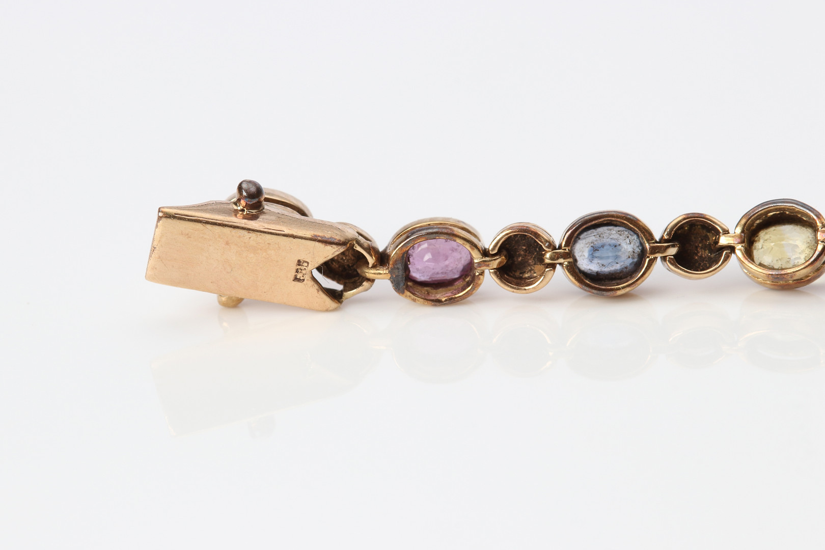 ARMBAND. 14k guld med rödrosa rubiner samt gula och blå safirer, totalvikt ca 8,9 gram.