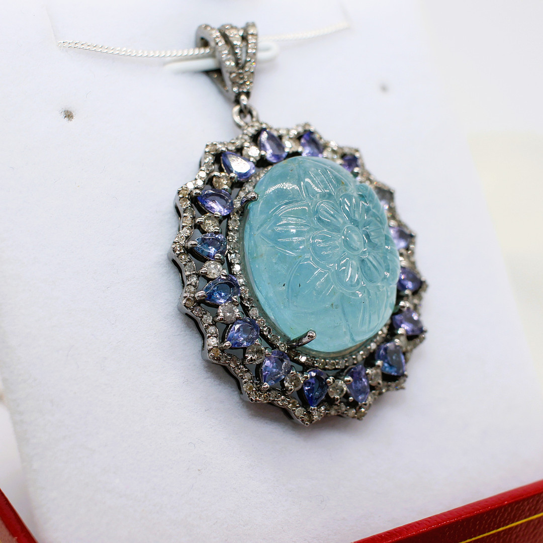 CARVED AQUAMARINE, DIAMOND & TANZANITE PENDANT.