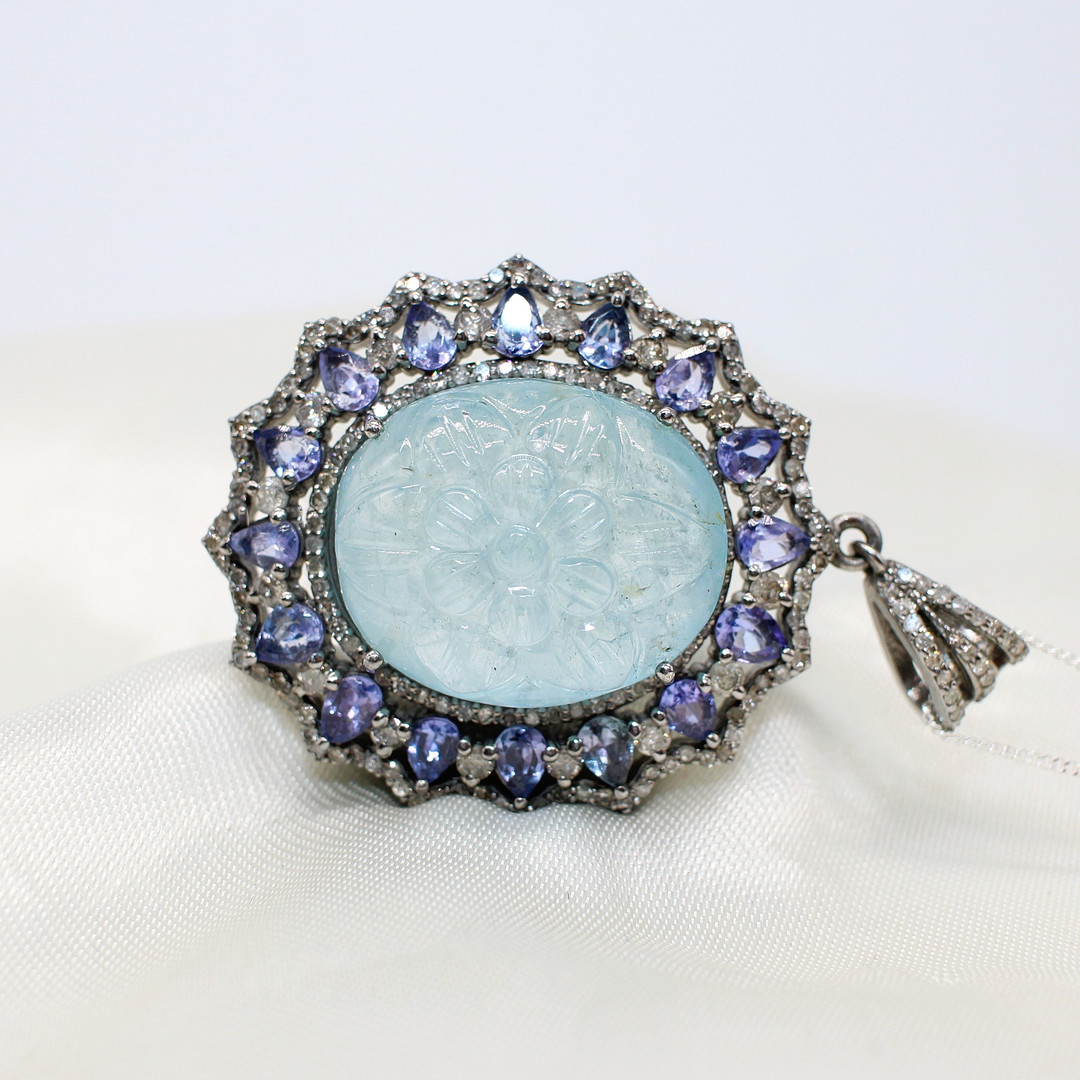 CARVED AQUAMARINE, DIAMOND & TANZANITE PENDANT.
