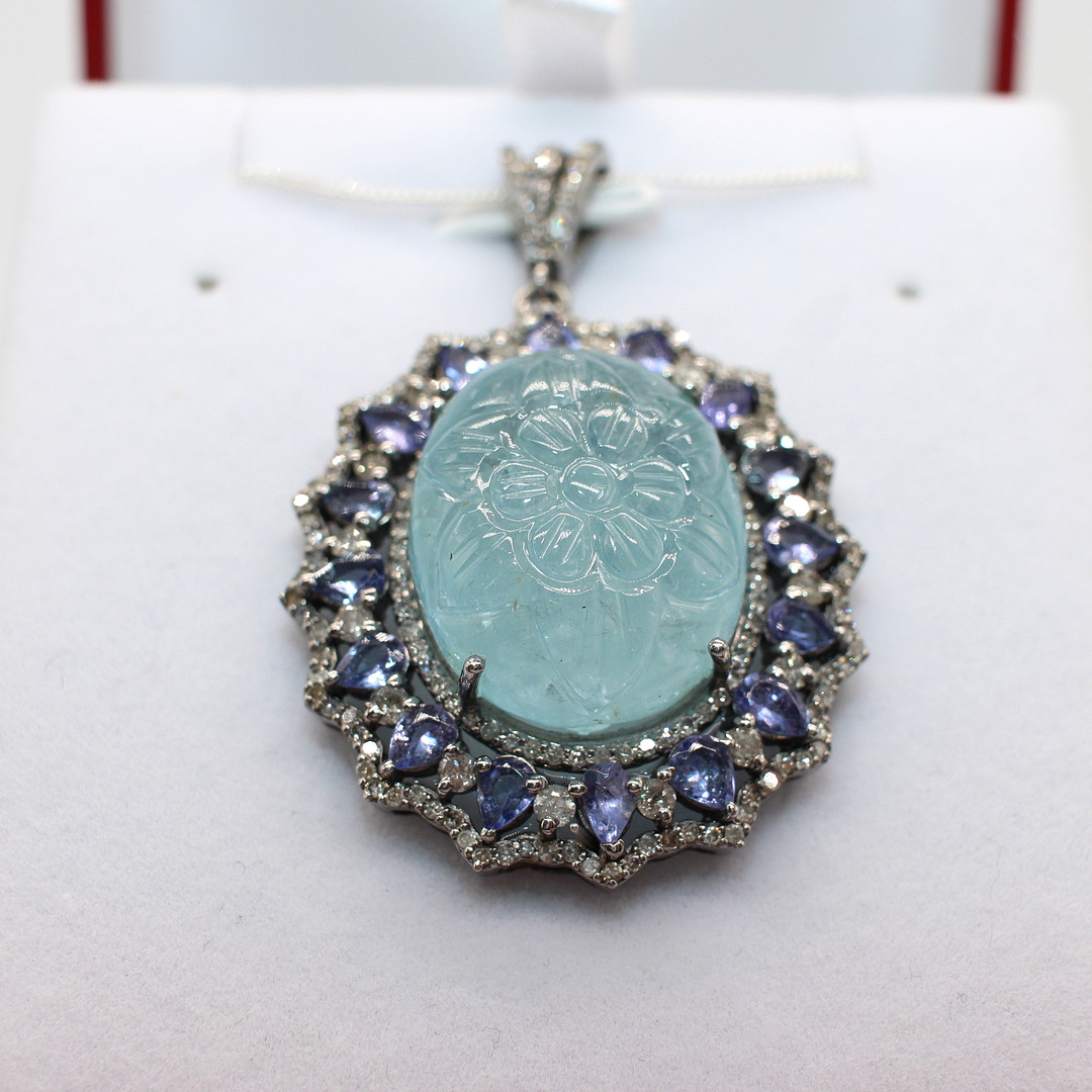 CARVED AQUAMARINE, DIAMOND & TANZANITE PENDANT.