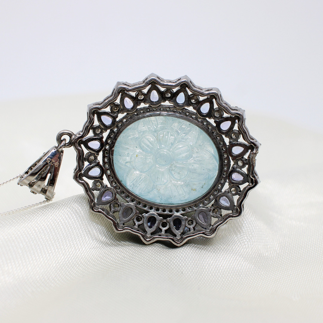 CARVED AQUAMARINE, DIAMOND & TANZANITE PENDANT.