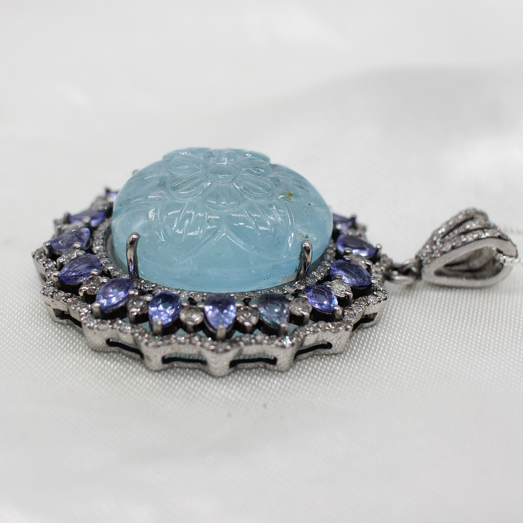 CARVED AQUAMARINE, DIAMOND & TANZANITE PENDANT.