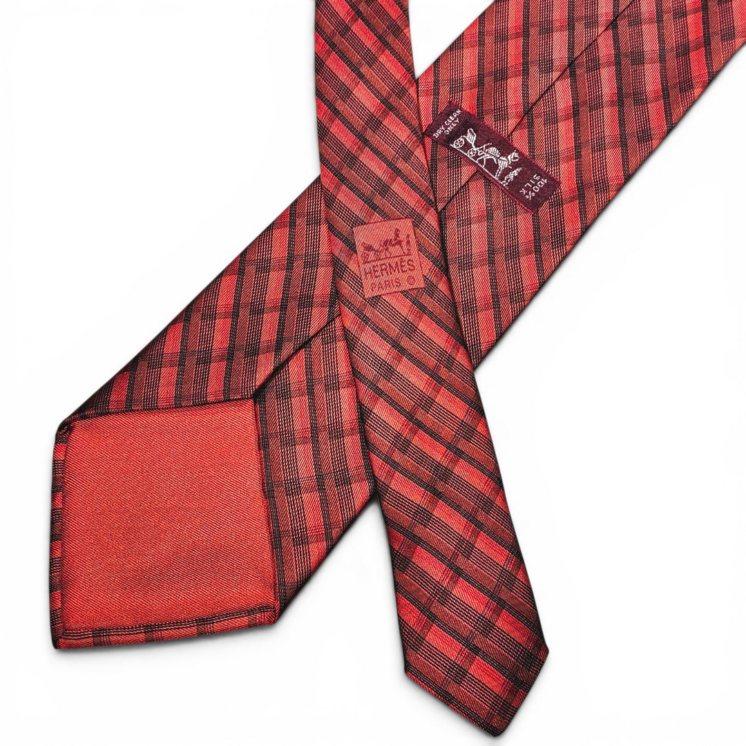 HERMÈS. Corbata en seda con franjas en tonos rojos.
