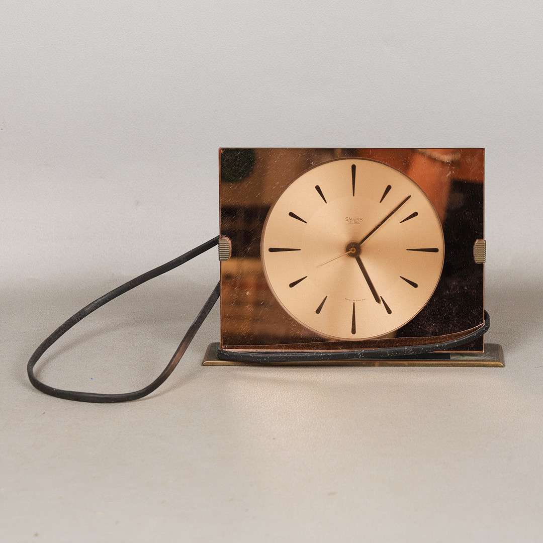 A SMITHS COPPER COLOURED GLASS ELECTRIC MANTEL CLOCK.