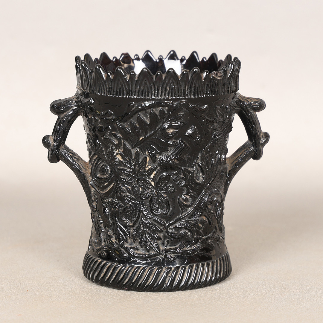 A 19TH CENTURY SCOTTISH MOULDED BLACK GLASS TWIN HANDLED VASE/POT.