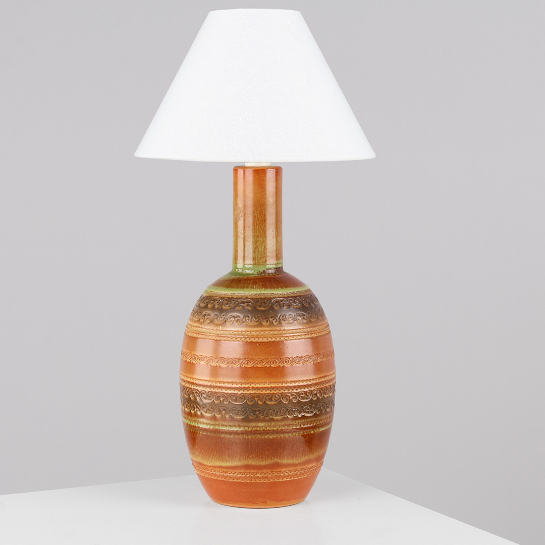 ITALIENSK DESIGN: Bordlampe af keramik glaseret i primært rødbrune og grønne nuancer, udsmykket med vandrette rækker af reliefmønstre, Italien, 1900-tallets anden halvdel.