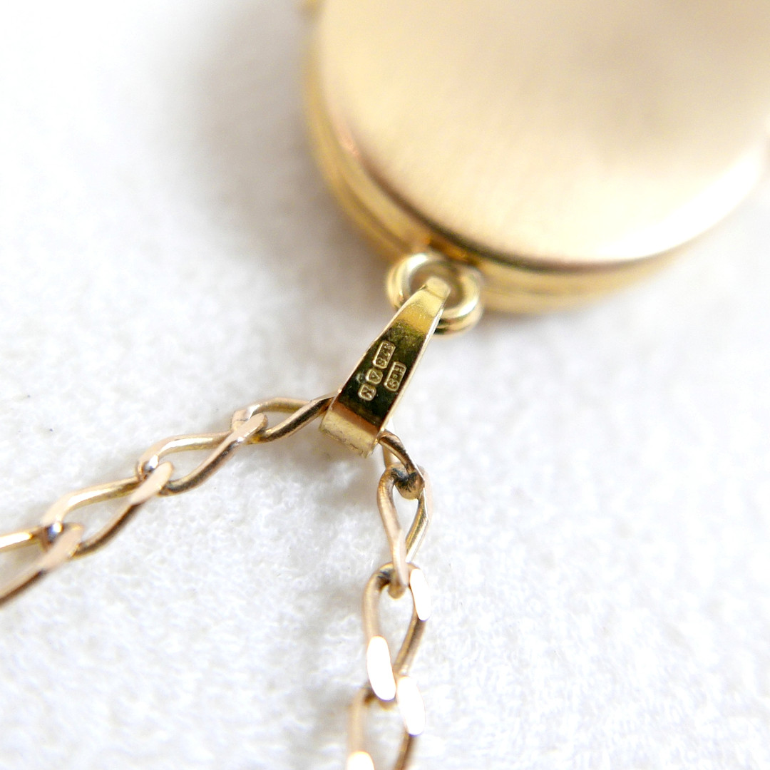 A 9CT GOLD NECKLACE AND LOCKET.