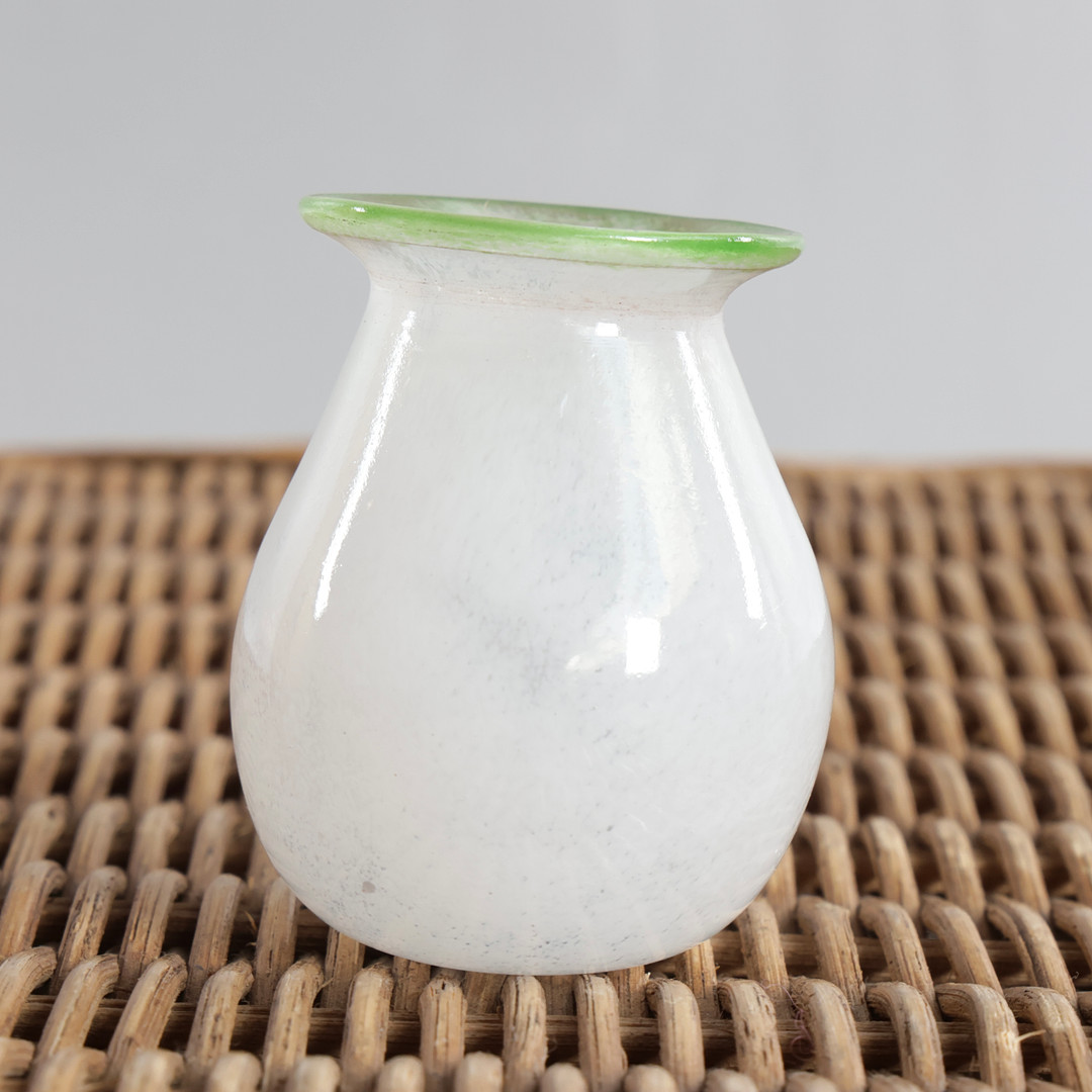 Lille vase af hvidt glas, munding med grøn kant. Ej signeret i bunden. Skandinavisk glasdesign.