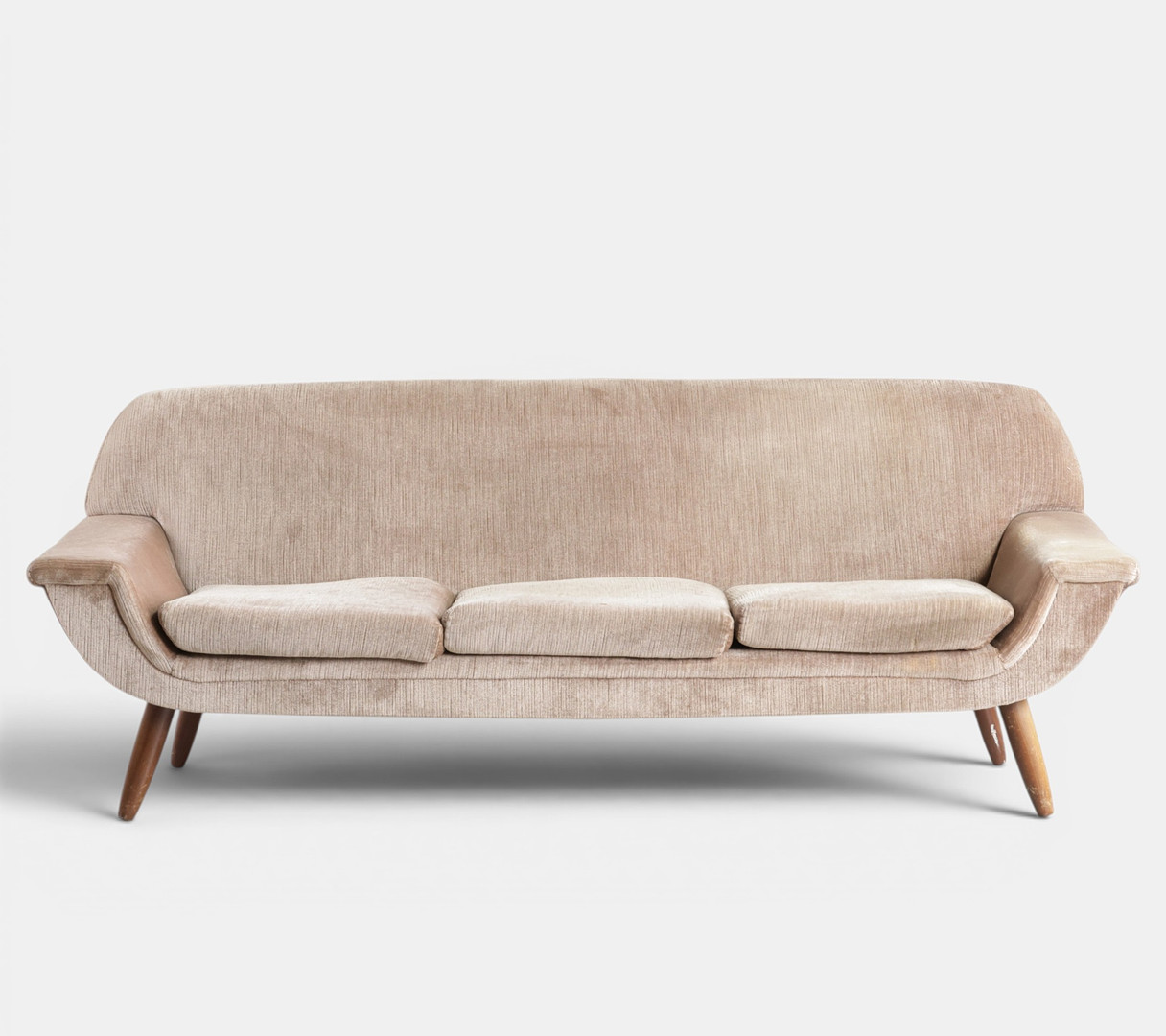 Fritstående tre-pers. sofa betrukket med velour, løse hynder i sæde, runde tilspidsede ben af teak. Danmark, 1960'erne.