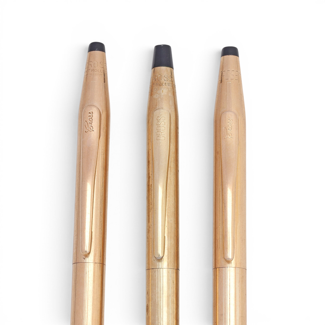 Gold-plated mechanical pencil and two ballpoint pens by Cross.