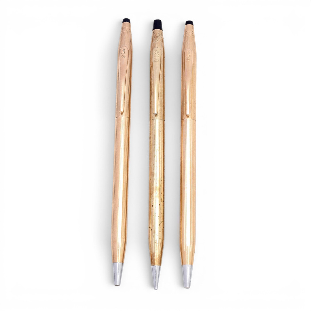 Gold-plated mechanical pencil and two ballpoint pens by Cross.