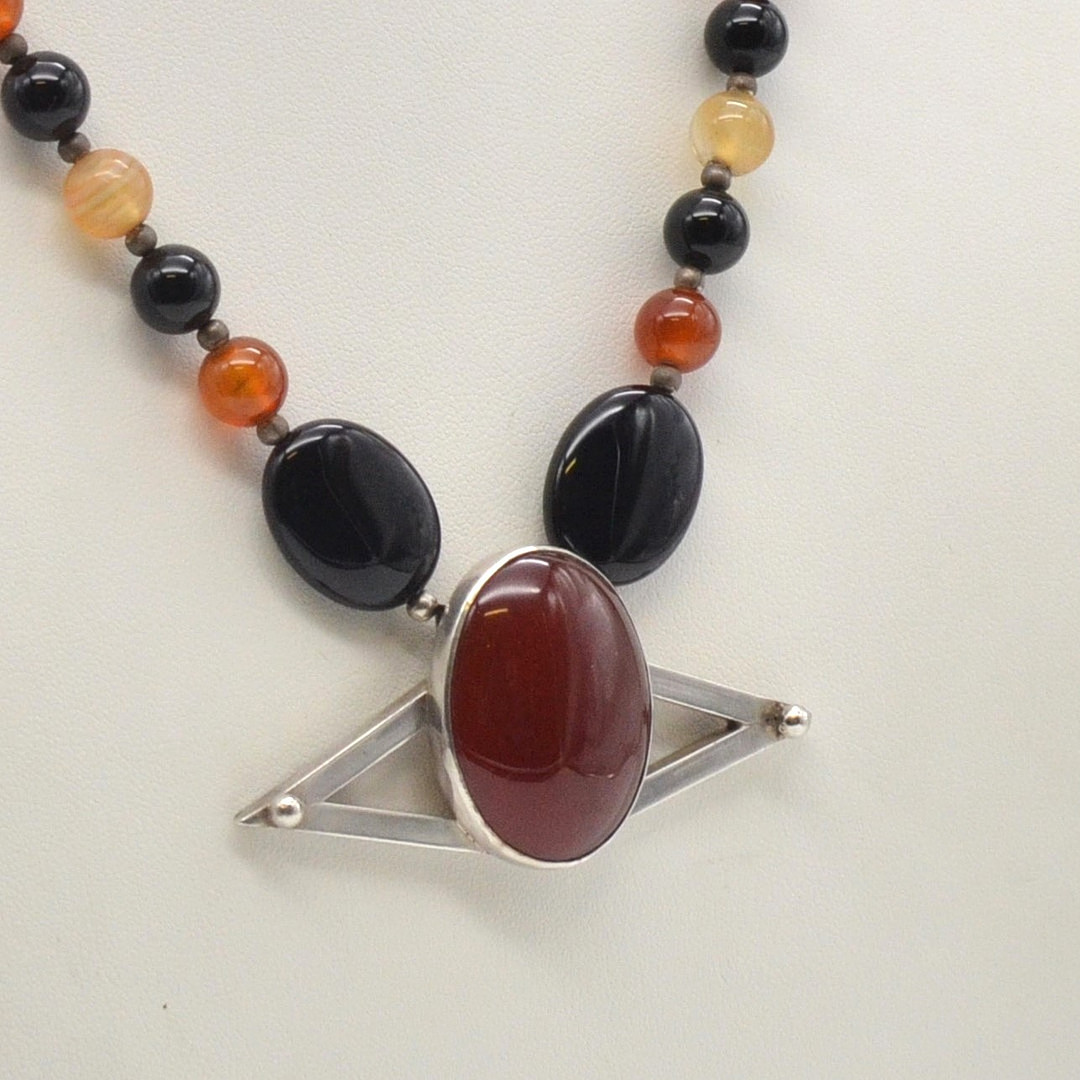 J. KÖHLE, DESIGNERCOLLIER MIT EINEM ANHÄNGER MIT ACHAT CABOCHON, FASSUNG AUS STERLINGSILBER, PERLEN AUS ACHAT, DEUTSCHLAND (PFORZHEIM), UM 1970ER JAHRE.