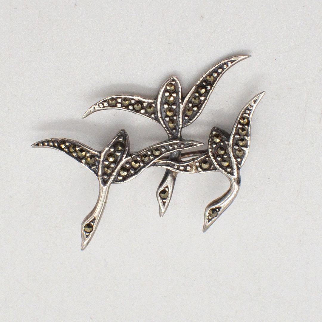 DESIGNERBROSCHE MIT MARKASIT-BESATZ, DREI VÖGEL, FASSUNG AUS STERLINGSILBER, UM 1950.