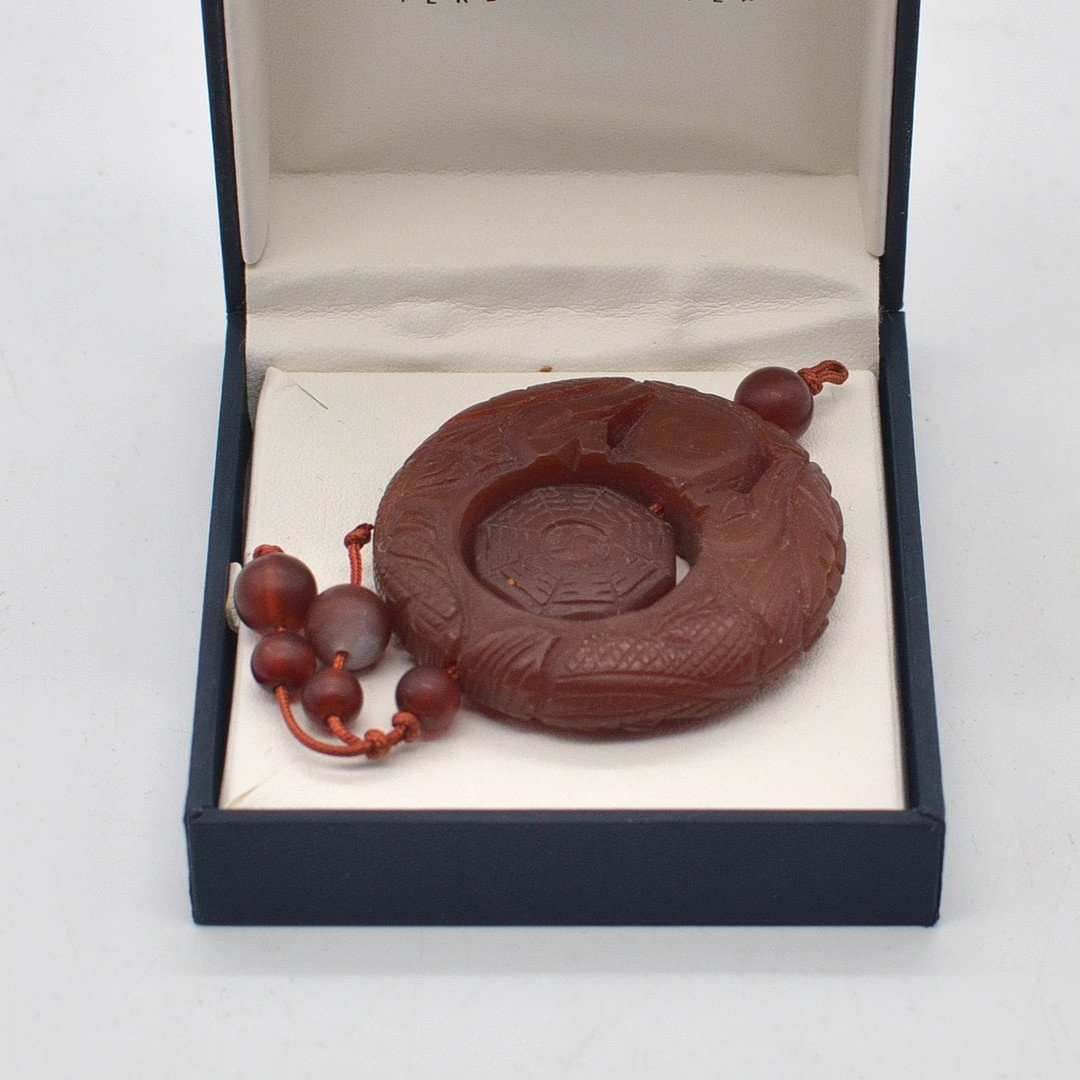 CHINESISCHES JADE AMULETT, TAICHI MUSTER UND DRACHEN, ROT, 20. JAHRHUNDERT.