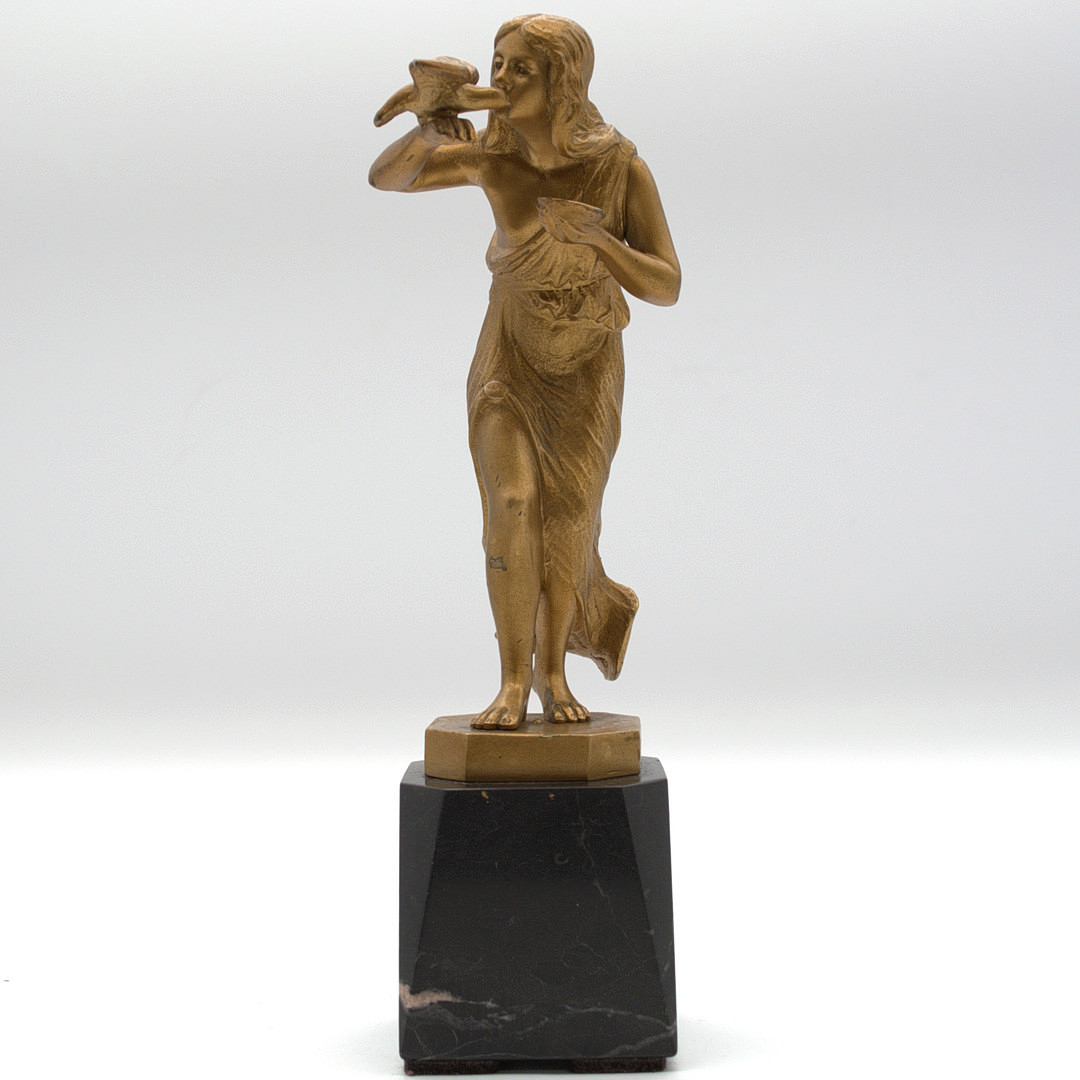 SKANDINAVISCHE SKULPTUR METALL VERGOLDET, JUNGE FRAU IN FLIESSENDEM GEWAND MIT VOGEL, SIGNIERT. JENSEN. AUF SCHWARZEM MARMOR SOCKEL FRÜHES 20. JAHRHUNDERT.