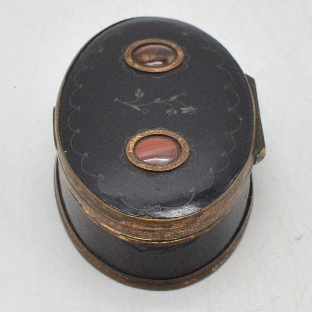 RUSSISCHE LACKDOSE, KLAPPDOSE IN SCHWARZ MIT BLUMENDEKOR, FASSUNG AUS HOLZ UND VERGOLDETEM KUPFER, MIT INTARSIEN AUS ACHAT, 19. JAHRHUNDERT.