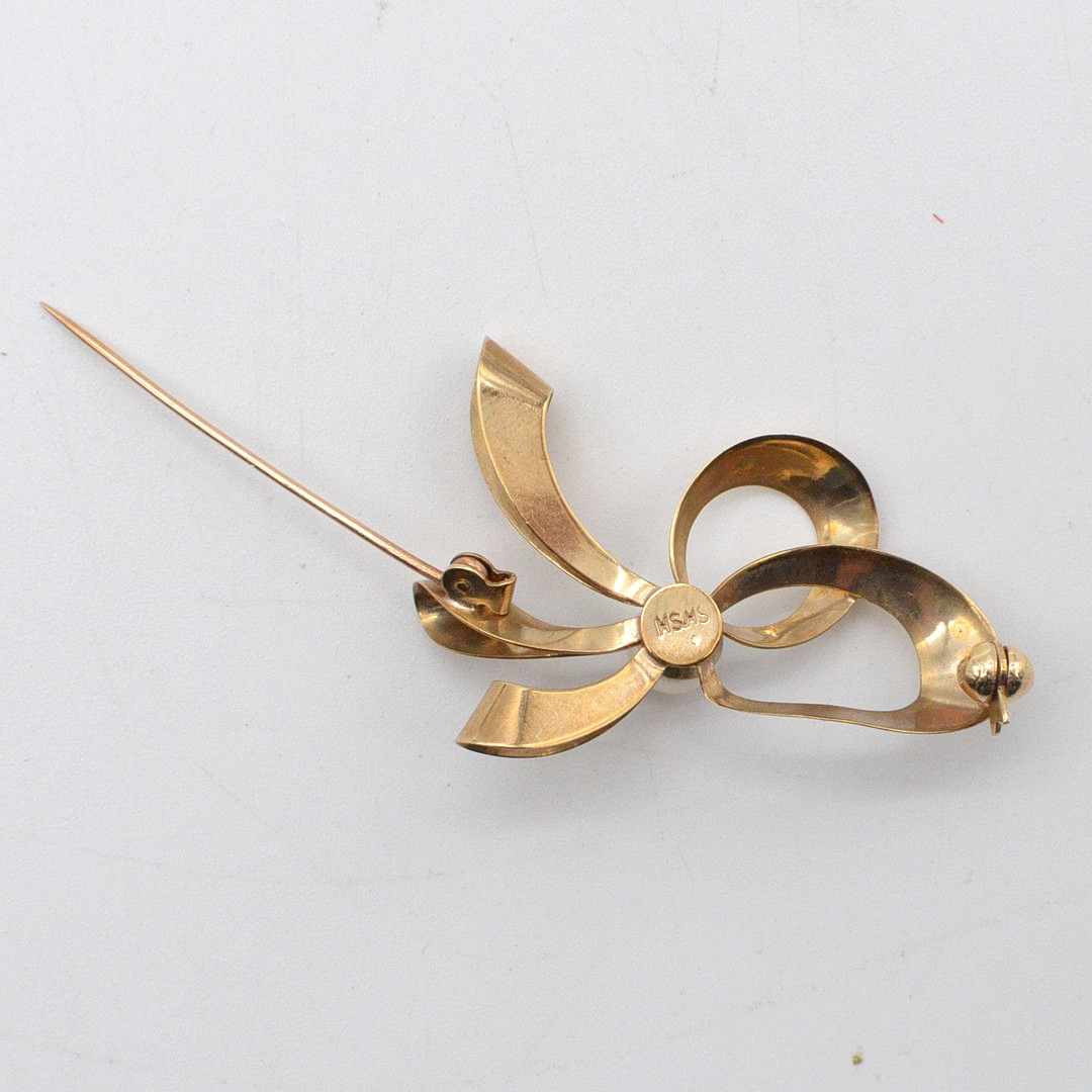 HERMANN SIERSBØL. DESIGNER BROSCHE, SCHLAUFE MIT PERLE, 8 KARAT GELBGOLD (GEPRÜFT), DÄNEMARK, MITTE 20. JAHRHUNDERT.