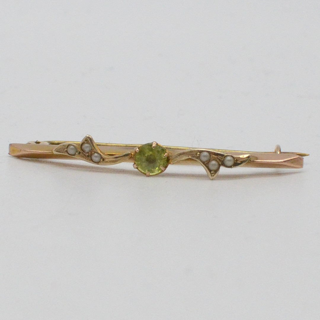 ANTIKE BROSCHE MIT 6X KLEINE PERLEN UND PERIDOT IM RUNDSCHLIFF, FASSUNG AUS 9 KARAT ROSEGOLD, HANDGEMACHT, UM 1900.
