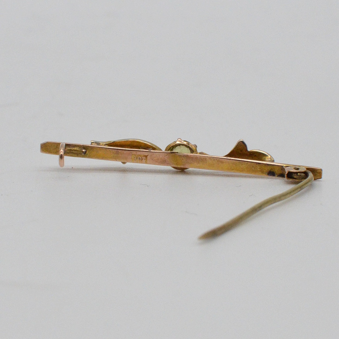 ANTIKE BROSCHE MIT 6X KLEINE PERLEN UND PERIDOT IM RUNDSCHLIFF, FASSUNG AUS 9 KARAT ROSEGOLD, HANDGEMACHT, UM 1900.