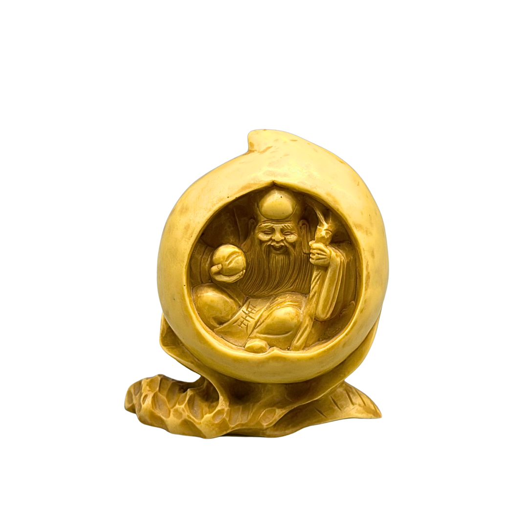 MINIATURFIGUR DES CHINESISCHEN GLÜCKSGOTT DER LANGLEBIGKEIT (SHOU XING) IN DER IM INNEREN DES PFIRSICHS DER UNSTERBLICHKEIT.