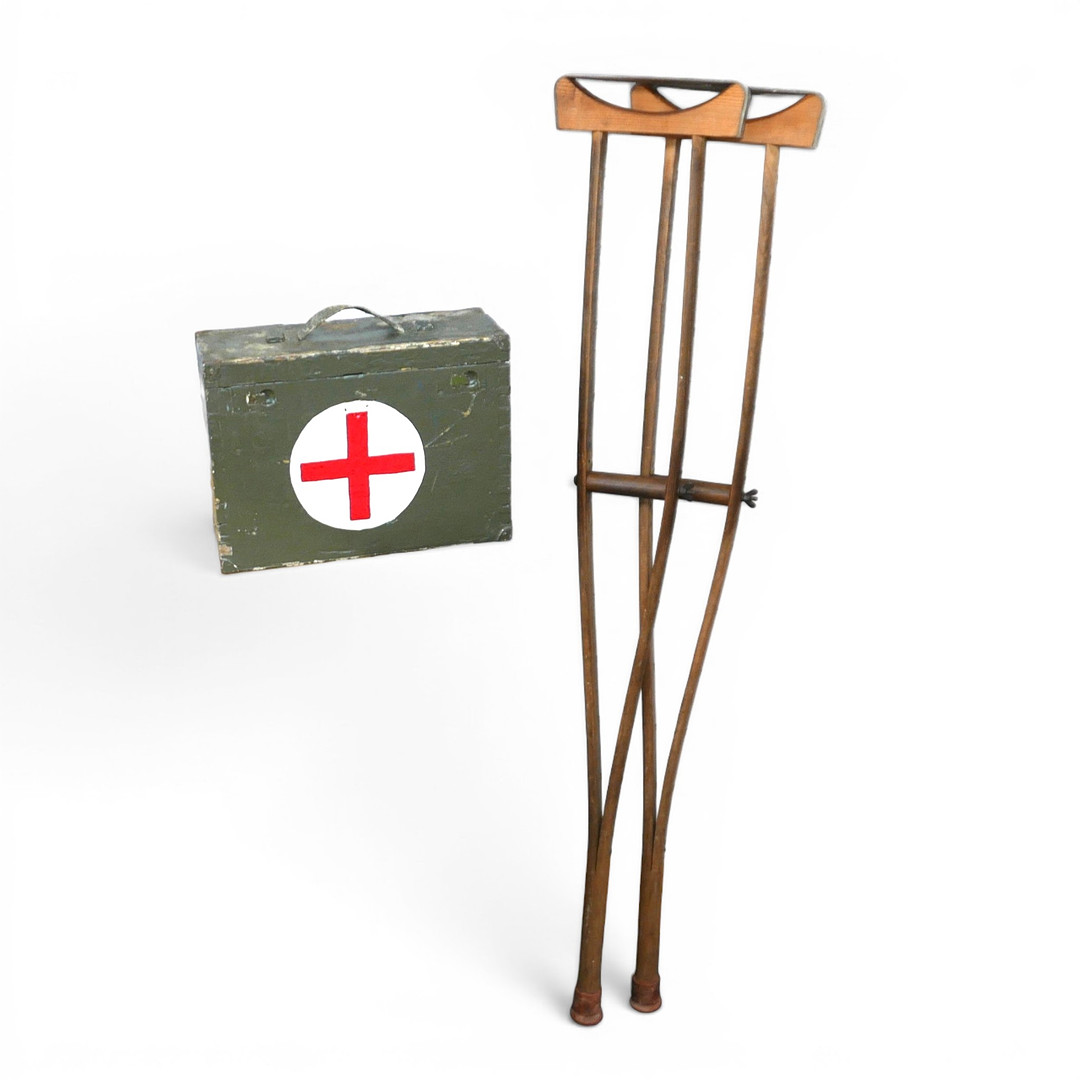 A PAIR OF MILITARY STYLE CRUTCHES AND AN FIRST AID BOX.