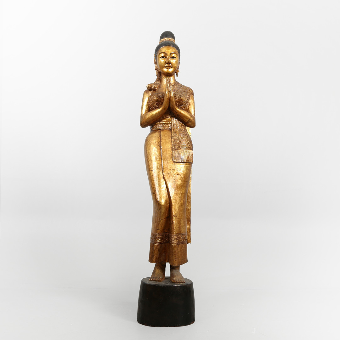 Stor figur af udskåret og forgyldt træ i form af stående kvinde, Thailand, 1900-tallet.